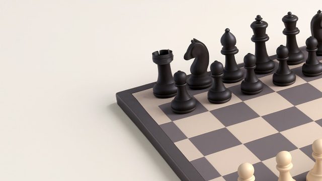 Schachfiguren in Grundstellung auf einem Brett.